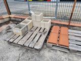 a pile of concrete blocks on a pallet next to a fence