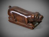 an old wooden sculpture of a dog laying down on its side