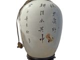 a white vase with asian writing on it on a stand