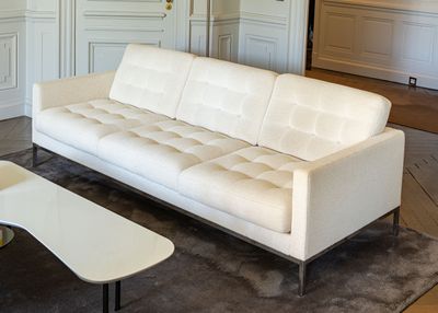 a white couch sitting in a living room next to a coffee table