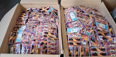 two boxes filled with different colored ties on top of a table