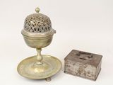 un petit objet en métal muni d'un couvercle et d'une petite boîte