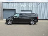 the black van is parked in front of a building in a parking lot
