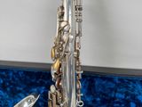 a person holding a silver saxophone in their hand