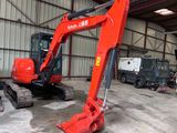 a red excavator that is parked in a building
