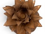 a small bronze flower on a white surface