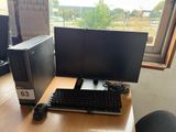 a computer desk with two monitors and a keyboard on it