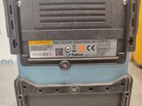 a close up of a blue and black machine in a warehouse
