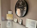une horloge accrochée au mur au-dessus d'un banc dans une pièce