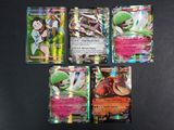 Quatre cartes Pokémon sont posées sur une surface noire