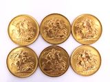 six gold sovereigns of different sizes and shapes