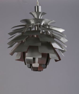 a metal light hanging from the ceiling in a room