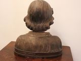 a statue of a woman sitting on top of a wooden table
