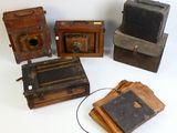 several old cameras are sitting on a white surface