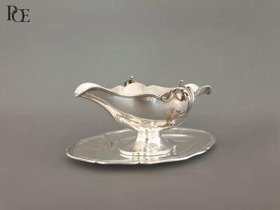 un service en argent ancien composé d'une assiette et d'une soucoupe posée dessus