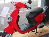 un scooter rouge garé devant une fenêtre