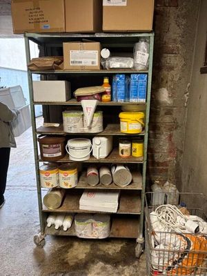 a shelf of paint and other items in a room
