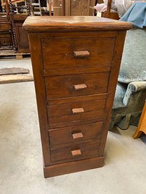 a tall wooden chest of drawers in a room
