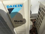 two air conditioners sitting next to each other on the ground