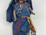 une poupée qui porte une robe bleue et un chapeau