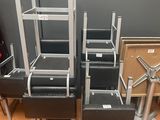four black leather chairs and a metal table in a room