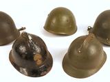 quatre casques sont alignés sur une surface blanche
