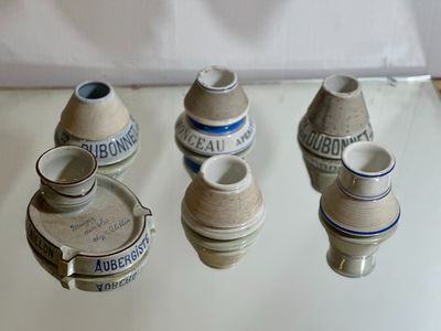 cinq petits vases posés sur une table, sur fond blanc