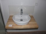 a white sink sitting on a wooden counter in a bathroom