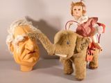 two stuffed animals that are next to a statue of a man
