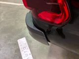 a red tail light on the back of a black car