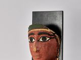 a close up of a sculpture of a woman ' s face on a stand