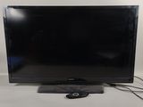 une télévision à écran plat posée sur une table blanche
