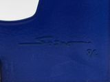 a close up of a blue vase with a bird on it