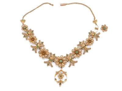 un collier en or orné de pierres vertes et blanches, montées sur une chaîne