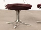 pair of chrome and velvet swivel chairs with red cushions