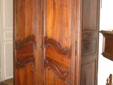 a large wooden armoire in a room with a fireplace