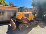 une photo d'un engin de chantier garé devant un immeuble