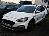a white ford focus parked in a lot with other cars