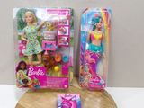 Deux poupées Barbie sont assises sur une planche à découper, à côté d'une boîte de brosses à dents
