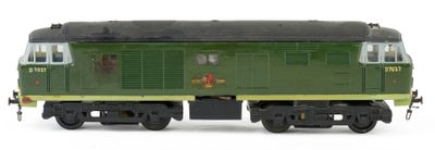a green train car that is sitting on a white surface