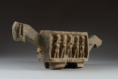 an ancient stone sculpture of a turtle with figures on it