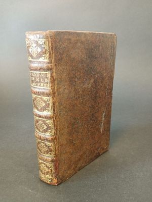 an old book sitting on top of a table on a gray surface