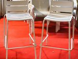 two white chairs sitting on a red carpet in a room