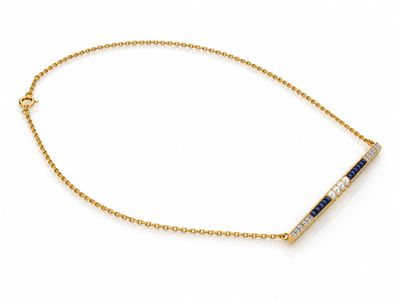 un bracelet en chaîne d'or orné d'une barrette sertie d'une pierre bleue et blanche