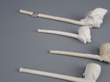 three white pipe heads are sitting next to each other on a gray surface