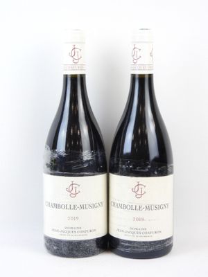 deux bouteilles de vin rouge posées l'une à côté de l'autre sur une surface blanche