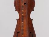 Un vieux violon est suspendu au plafond dans une pièce.