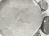 a silver plate with some rocks around it