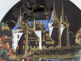 a decorative plate with a castle on it on a table