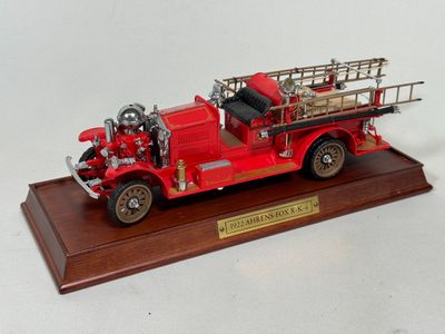 a model of a red fire truck on a wooden base